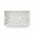 White plastic junction box backplate inside a clear plastic hanging retail bag, photographed on a white background.